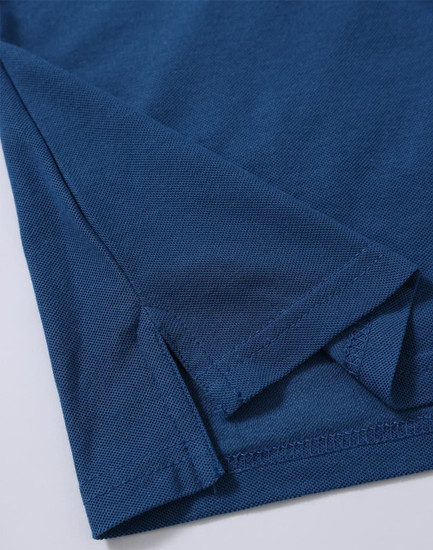A close-up of a dark blue polo shirt featuring a folded hem and sleeve detail. The shirt has a subtle texture and branding.