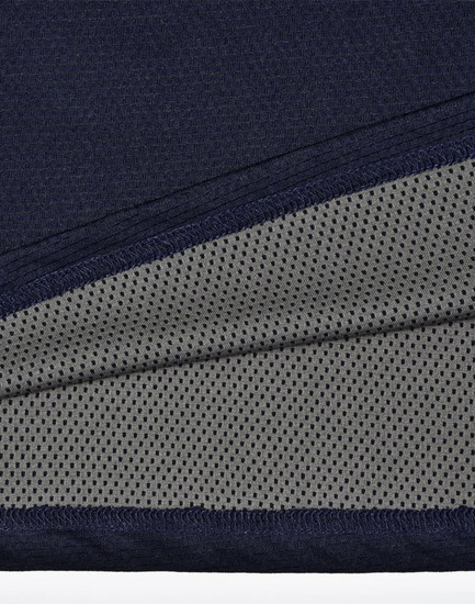 A close-up of a navy polo shirt detailing with a grey mesh inner lining, featuring a logo.
