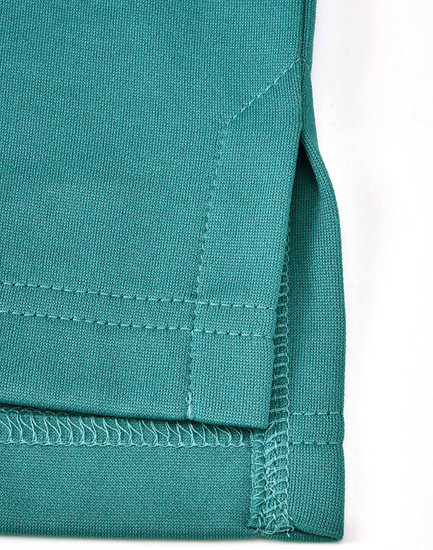 A close-up of a teal men's sustainable poly/cotton polo shirt, featuring a detailed hem and stitching.