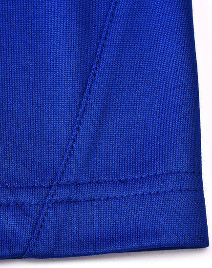 A close-up of a blue polo shirt featuring contrast stitching and a tag with a logo.
