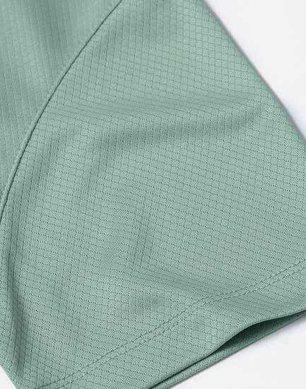 A close-up of a mint green jacquard knit fabric, showcasing its texture and pattern detail.