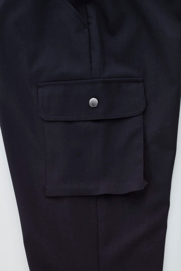 A close-up of black women's cargo pants featuring a side pocket with a button closure and a smooth fabric finish.