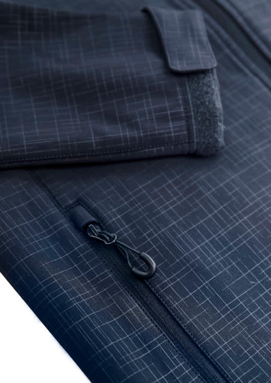 A close-up of a women's navy blue soft shell jacket displaying a textured pattern and zip details. Features a pocket.