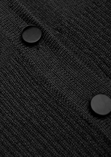 A close-up of a black cardigan featuring textured fabric and two round buttons.