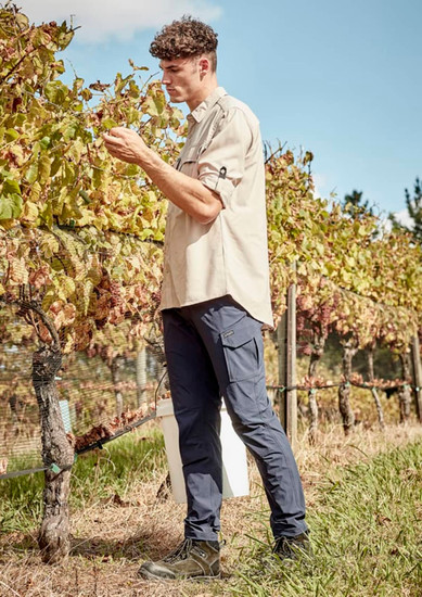 Men's lightweight outdoor pants in navy, featuring cargo pockets, worn by a person in a vineyard setting.