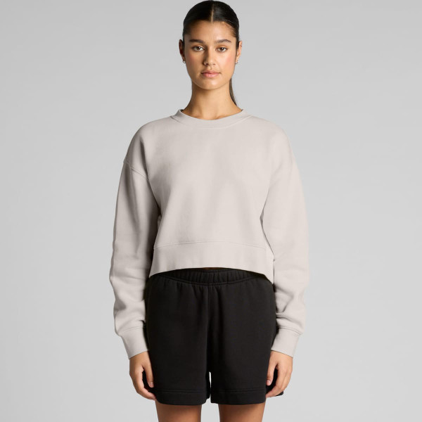 A light grey cropped jumper with a relaxed fit, paired with black shorts, featuring a branding logo.