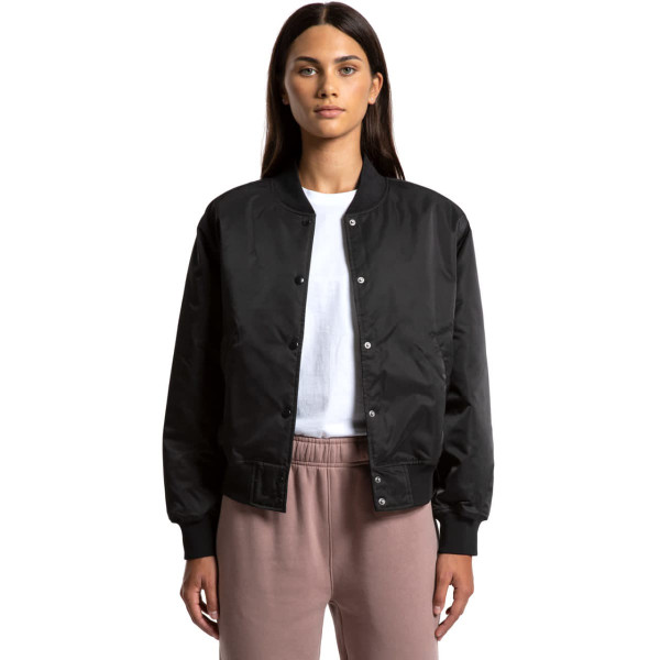 A black varsity bomber jacket with a snap button front, worn by a model. Features a logo on the chest.