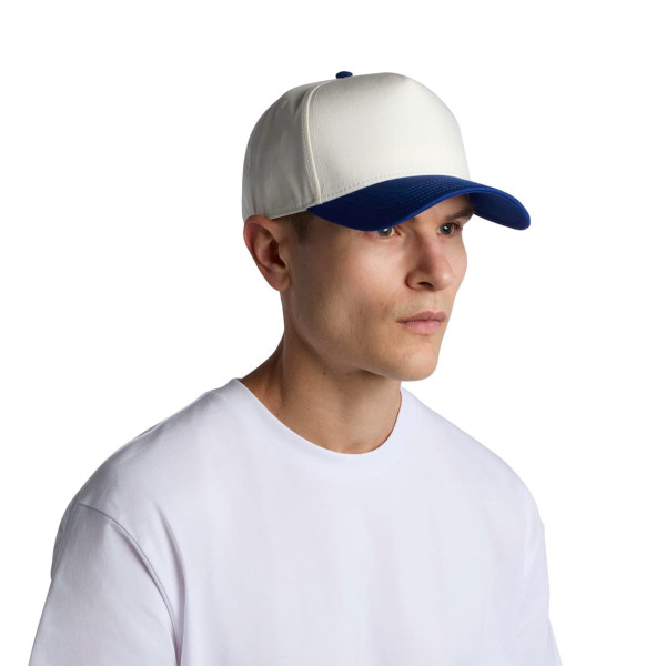 A two-tone cap featuring a white front and a blue brim, worn by a young man in a plain white t-shirt.