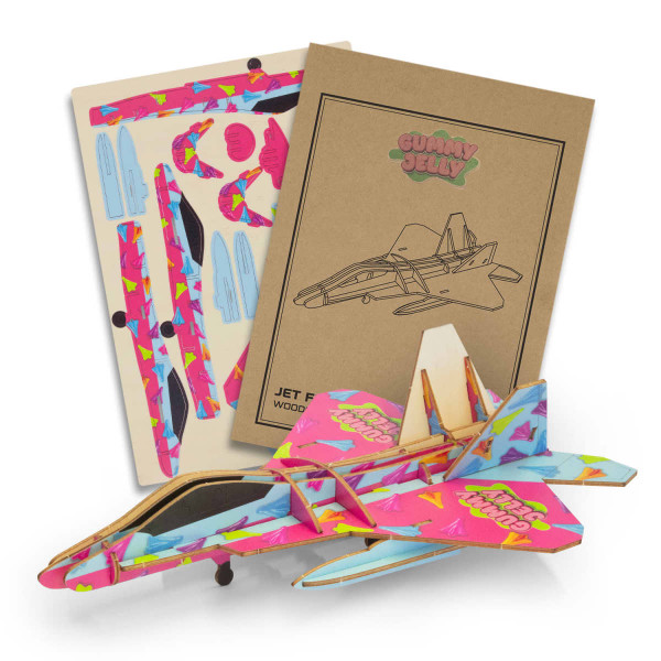A vibrant pink and blue wooden model jet with accompanying assembly instructions and decorative pieces.