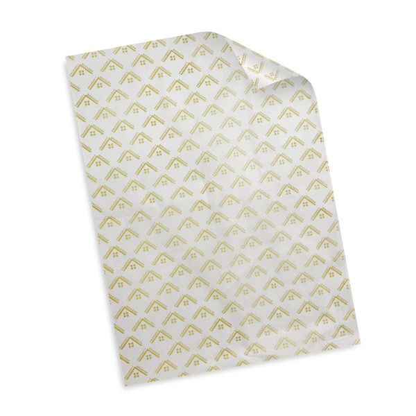 A sheet of white tissue paper featuring a patterned design in gold. The paper has a slight sheen and a folded corner.