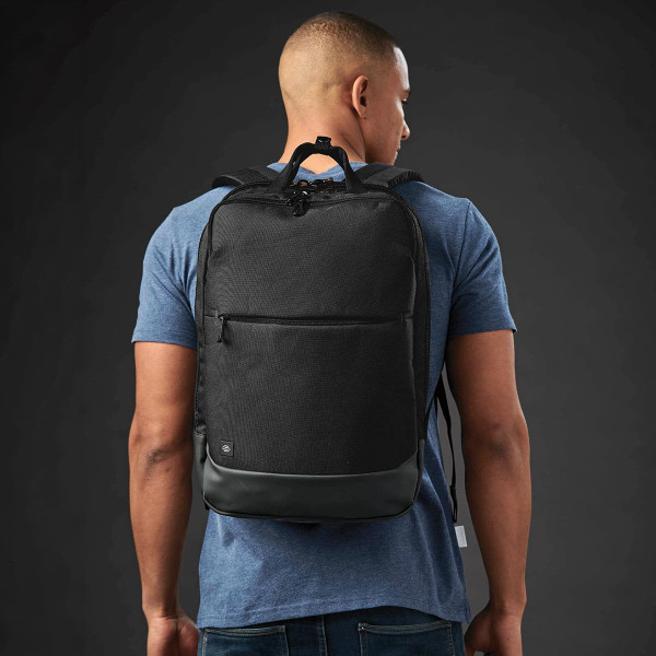 A black laptop backpack is worn on a person's back, featuring a sleek design and a matte finish.