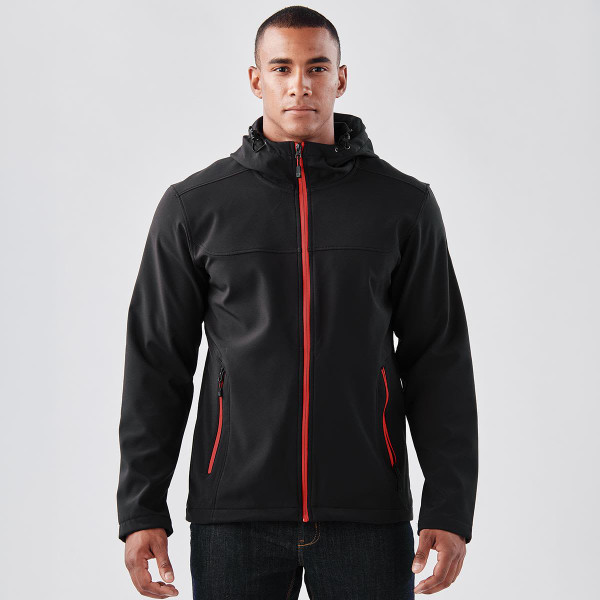 A black softshell hoody with red accents, featuring a zip front, zip pockets, and a hood. Includes branding.