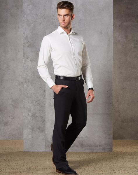 A man wearing black stretch wool blend pants paired with a white shirt and black shoes, standing in a modern setting.