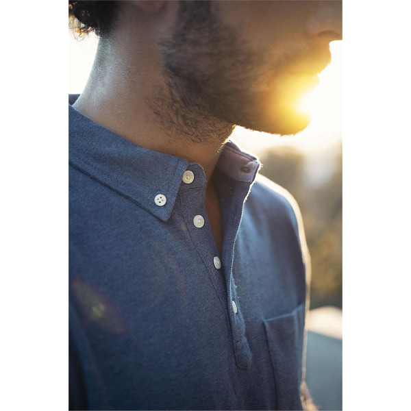 A men's polo shirt in blue with a collar, buttons, and a chest pocket, featuring soft lighting effects.