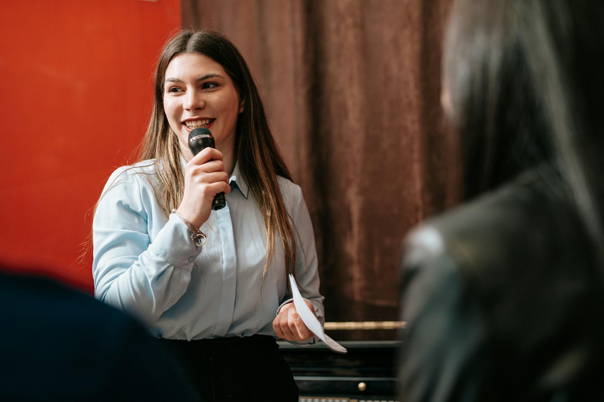 Woman speaking into a microphone during a conference panel discussion