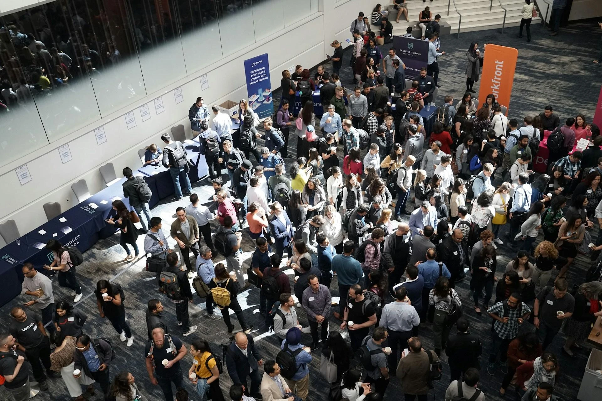 Overhead view of attendees networking at a conference exhibition hall