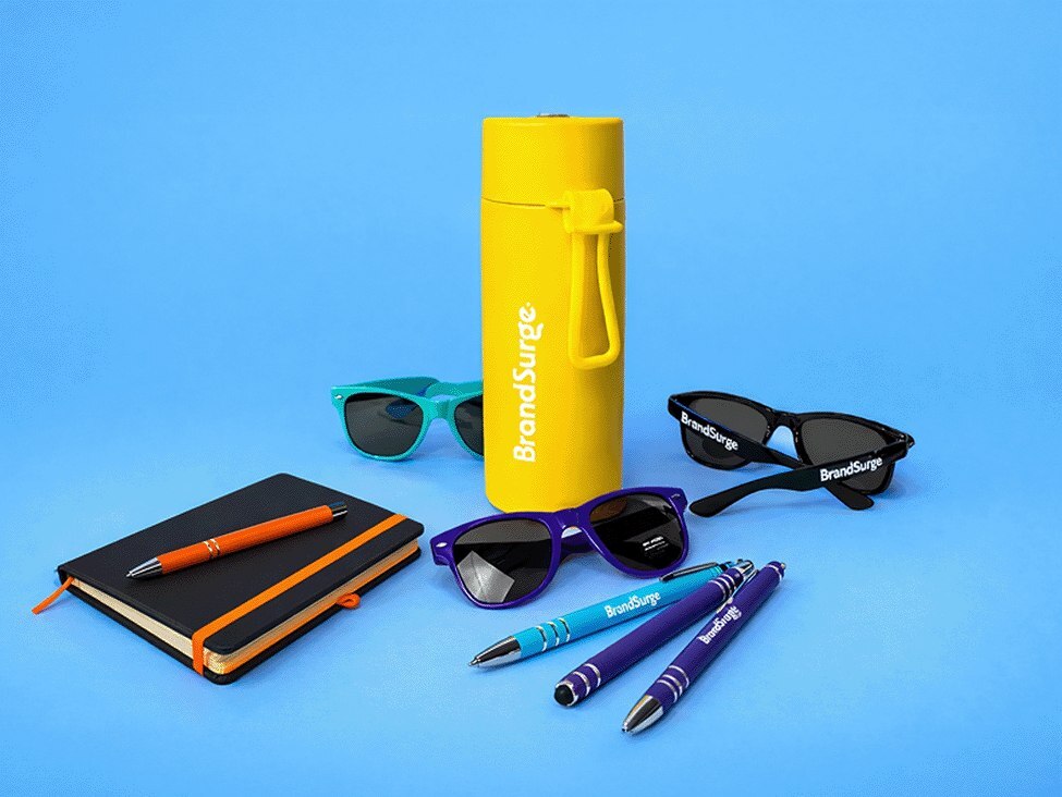 Branded pens, bags and notebooks laid out for a conference stand