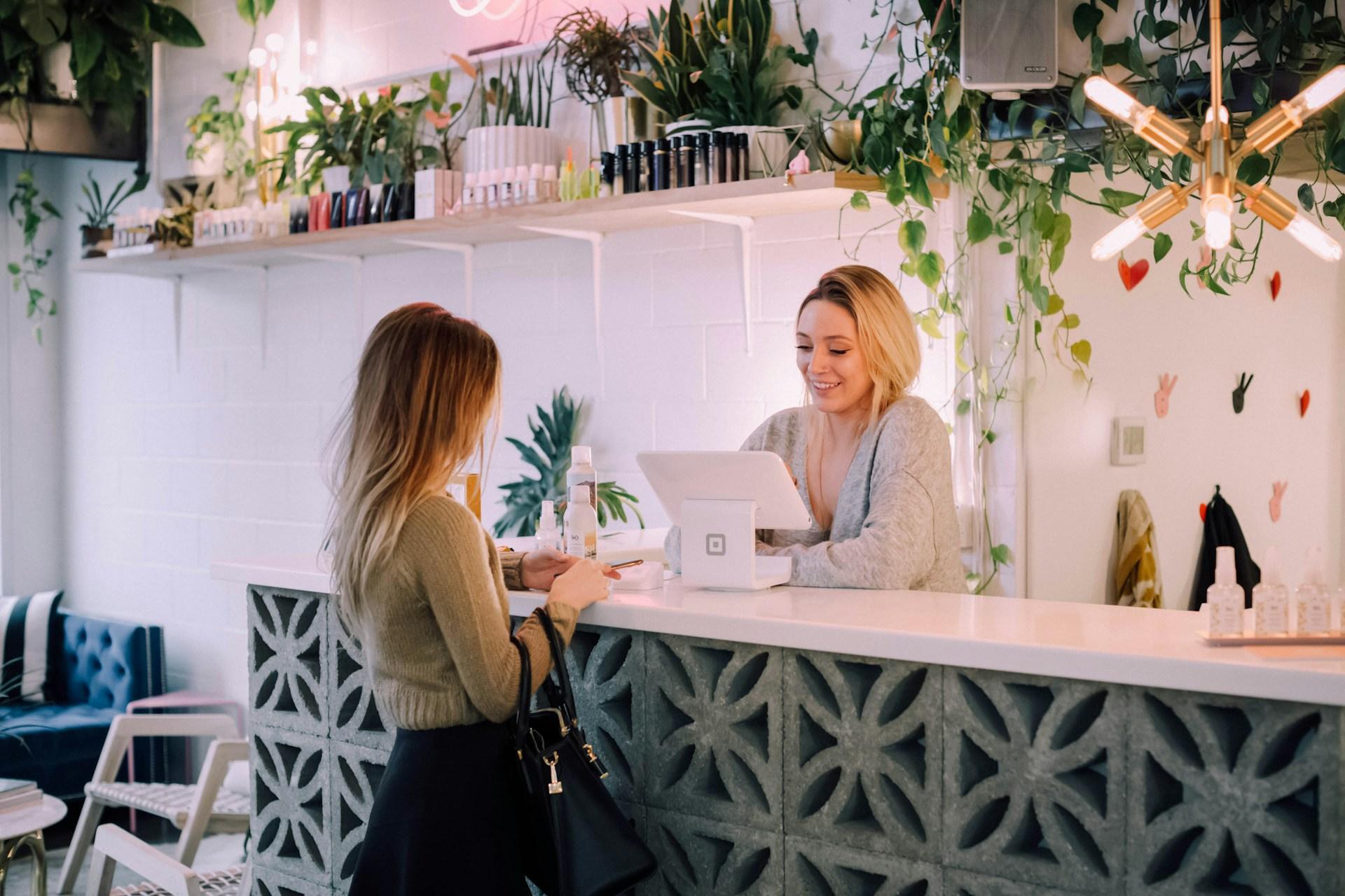 Small business owner greeting a customer at a branded reception counter in Australia