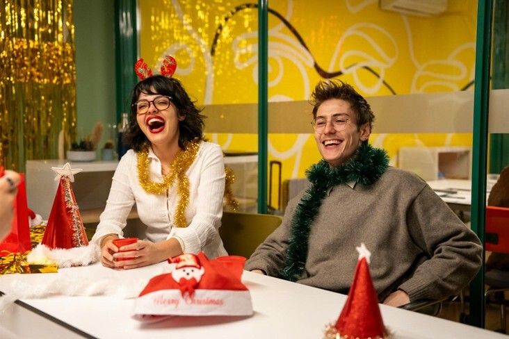 Two members of staff laugh and smile together during the office Christmas party