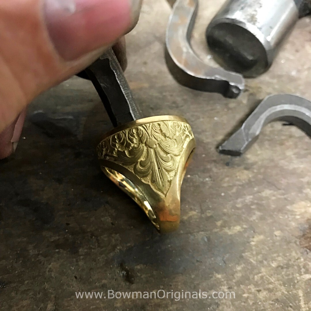 Ned Bowman stamping a handmade 18k gold ring with hallmarks at the Bowman Originals workshop.
