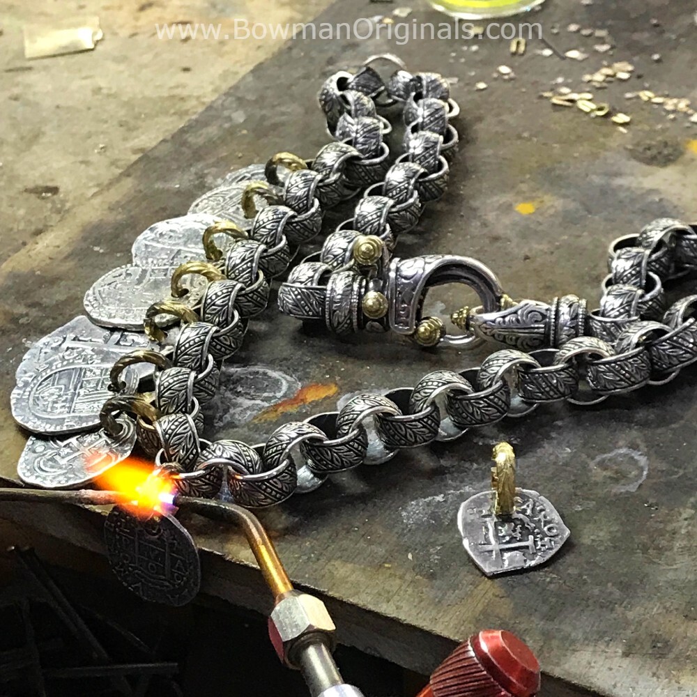 Precision artisan working on a workbench at Bowman Originals soldering gold links on the Medallion Necklace