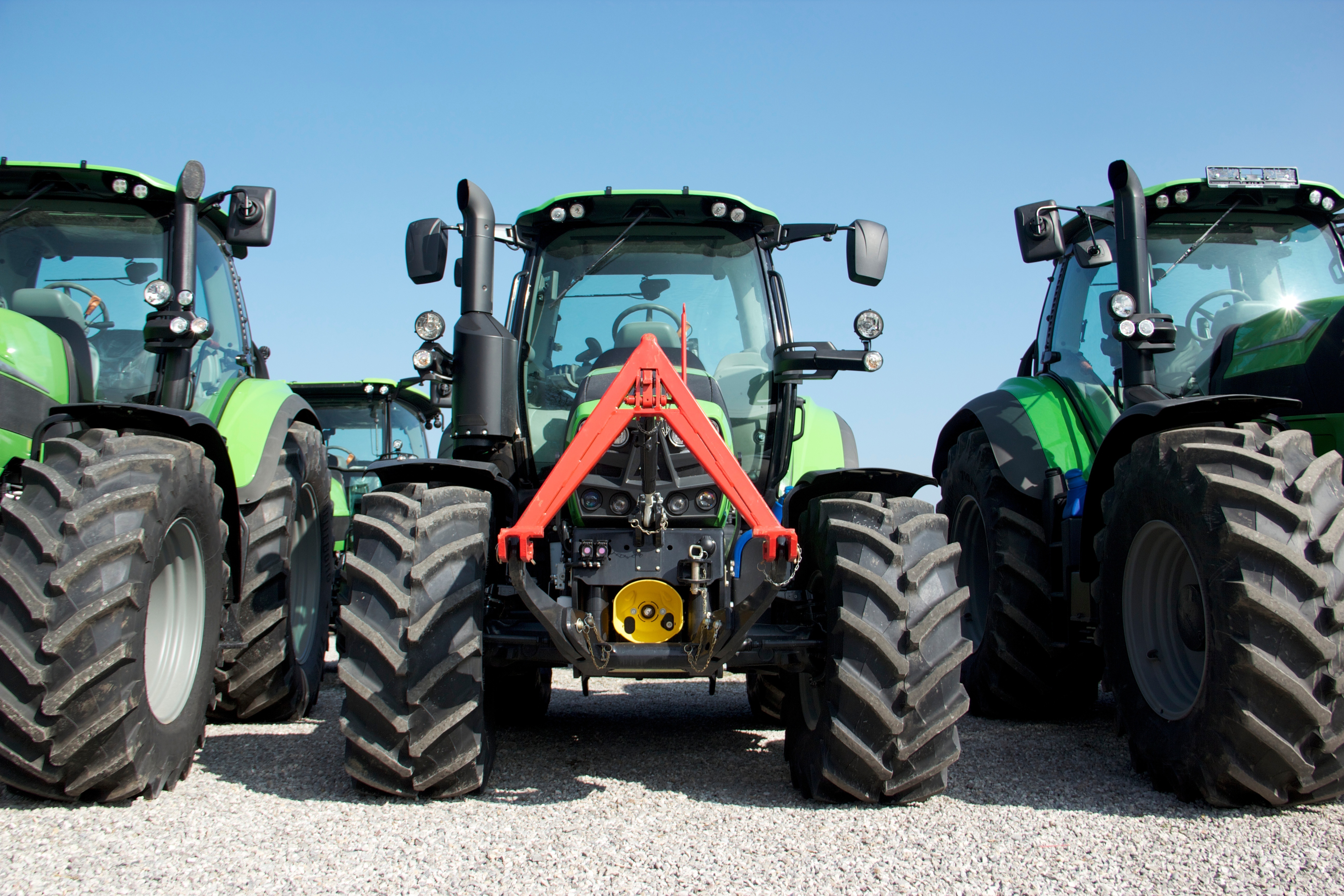 Three green tractors lined up in a row