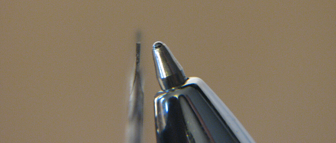 Thin saw blade next to pen tip