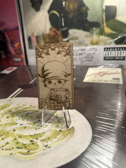 Laser-engraved wooden magnet featuring Tony Tony Chopper from One Piece. The design showcases Chopper in his signature hat with detailed linework, creating a unique and durable anime-inspired collectible for fans.