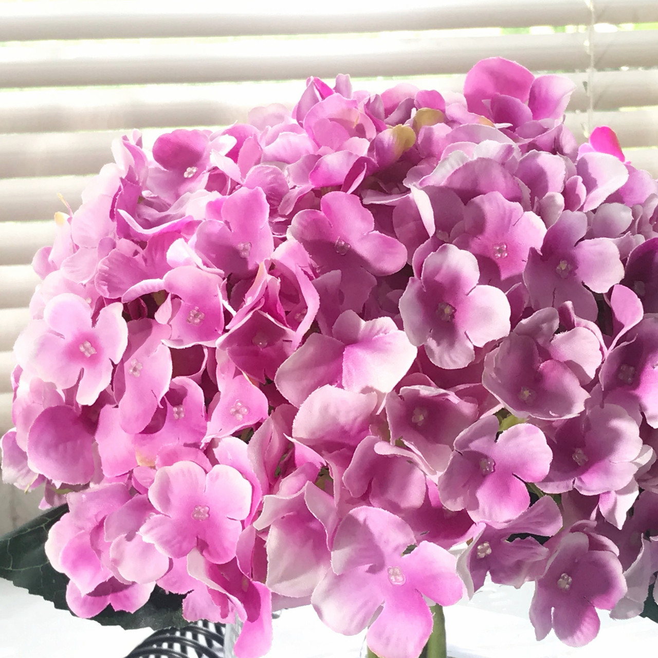 purple artificial flowers in vase