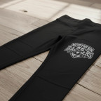 Flat lay of a pair of black spandex leggings showing a large, single-color gray stretch screen print transfer