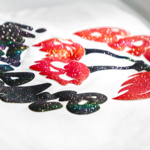 Close-up of Easy® Puff Glitter HTV showing sparkling glitter and 3D puff effect on fabric. Close-up of Easy® Puff Glitter HTV showing sparkling glitter and 3D puff effect on fabric.