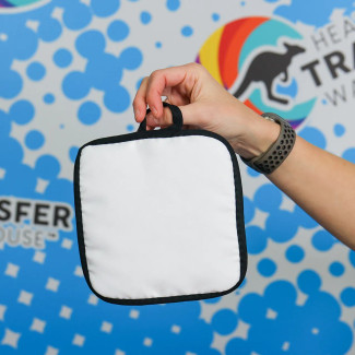 6 3/4 inch white quilted hot pad with black trim, showing the soft cotton quilted surface.