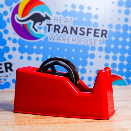 Sublimation tape dispenser sitting on a table with tape in it