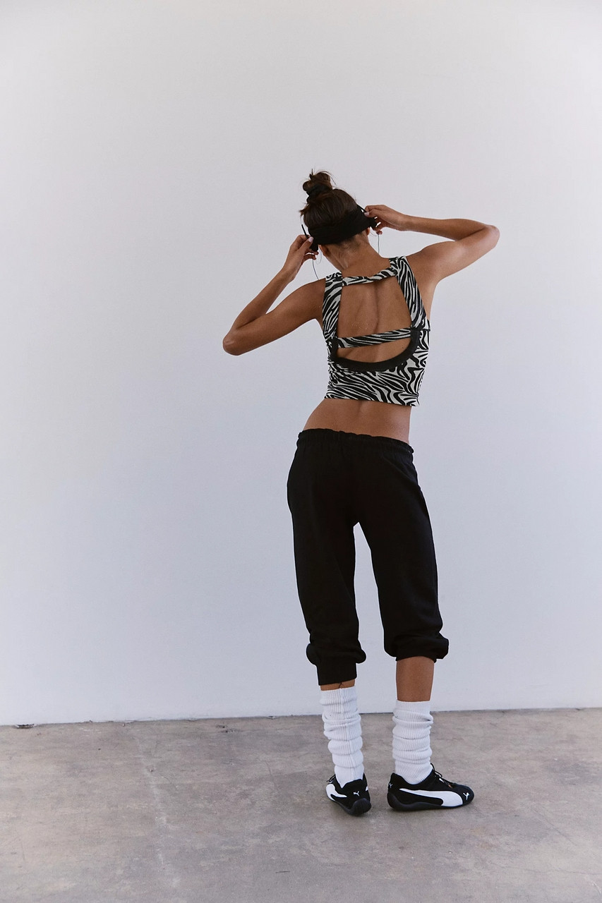FP Movement Women's Flutter Jogger, woman wearing black joggers, white socks, and black sneakers