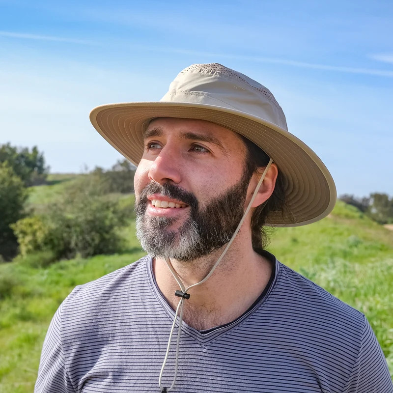 Sunday Afternoons Women's Cruiser Hat, wide-brim beach hat with chin strap worn outdoors on a sunny day.