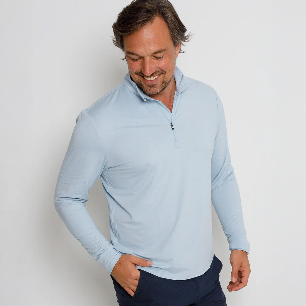 Anderson Ord Men's Hightower Pullover, image of a smiling man wearing a light blue pullover with a half-zip collar, standing against a plain background.