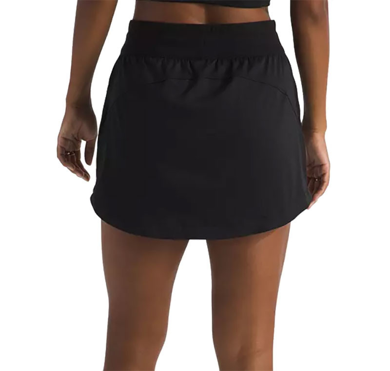 The North Face Women's Aphrodite Arise Skort, black athletic skort worn by a model showing the back view with an elastic waistband and skirt overlay.