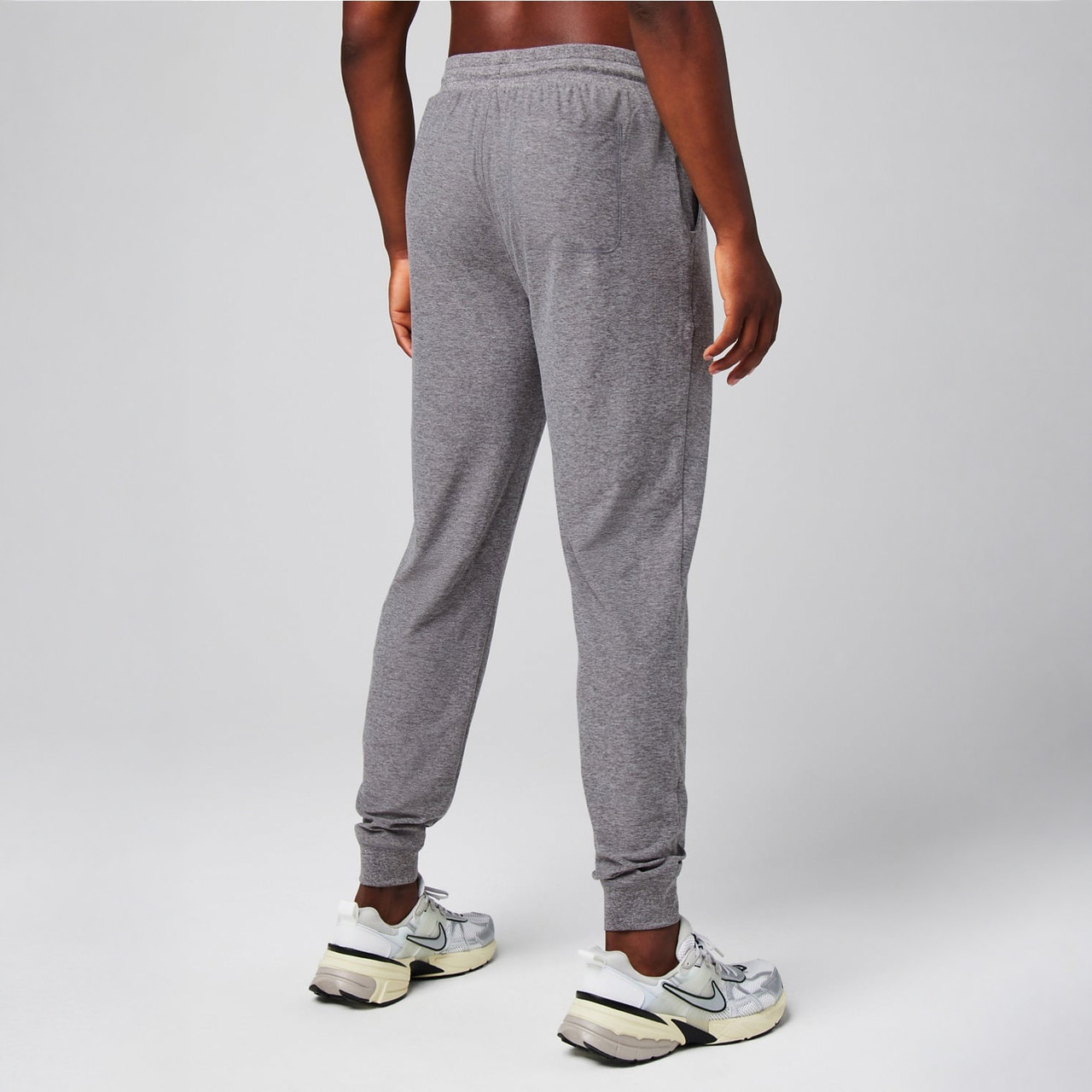 Fabletics Men's The Cloud Jersey Jogger, gray jogger pants made from lightweight, breathable fabric, featuring an elastic waistband and cuffed ankles.