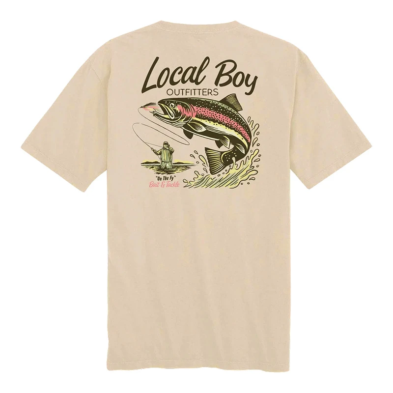 Local Boy Men's Trout Fly SS Tee, beige short-sleeve T-shirt featuring a graphic of a fishing scene with a large trout and a fisherman, highlight of outdoor fishing apparel.