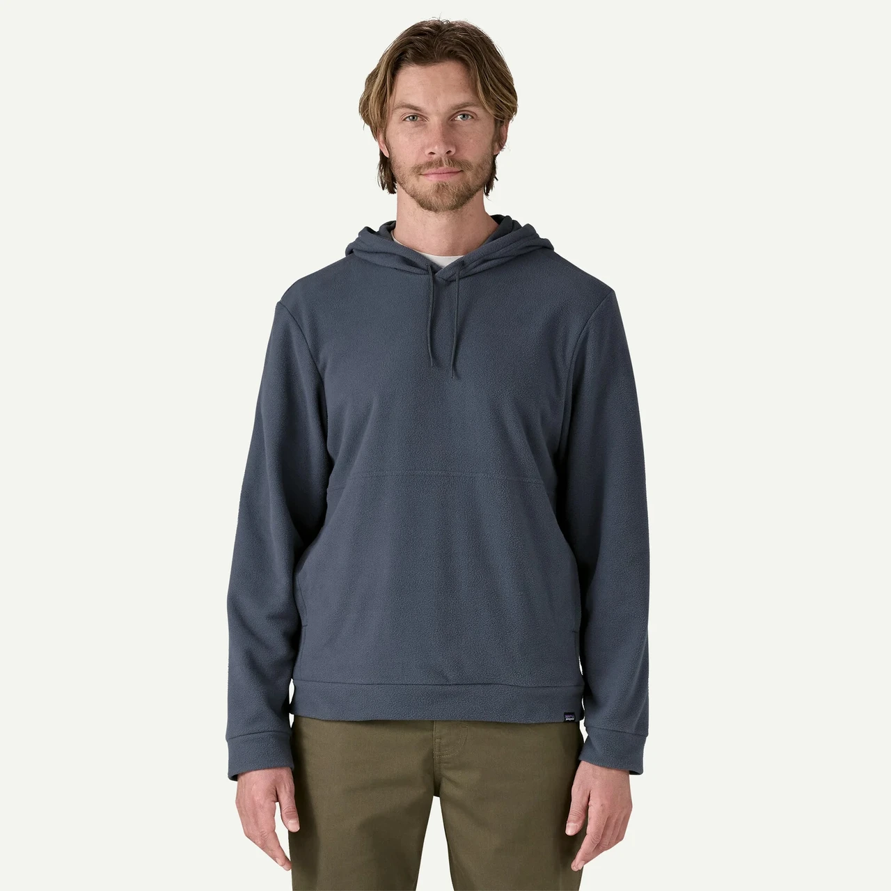 Patagonia Men's Micro D Hoody, model wearing a slate-blue fleece pullover hoodie with drawstrings and a kangaroo pocket against a plain background.