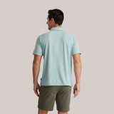 Free Fly Men's Bamboo Flex Polo II, a man wearing a light blue polo shirt with a collared neck and short sleeves, styled casually with khaki shorts.