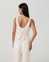 Vuori Women's Trestles Twill Button Front Top, front view of a woman wearing an off-white sleeveless button-front twill top with a tie at the back in a relaxed fit.