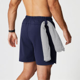 Fabletics Men's The One Short Lined - 7" Inseam, navy shorts with a grey hoodie tied around the waist.