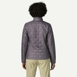 Patagonia Women's Nano Puff Jacket, front view of a woman wearing a lightweight, insulated quilted jacket in a muted purple color, designed for outdoor warmth and comfort.