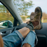 Blundstone Unisex Classic Chelsea Boot, rugged brown leather Chelsea boots worn by a person with jeans and gray socks relaxing in a car.