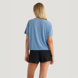 Free Fly Apparel Free Fly Women's Elevate Lightweight Tee, a woman wearing a light blue casual t-shirt with a relaxed fit and short sleeves, paired with black shorts against a plain white background.