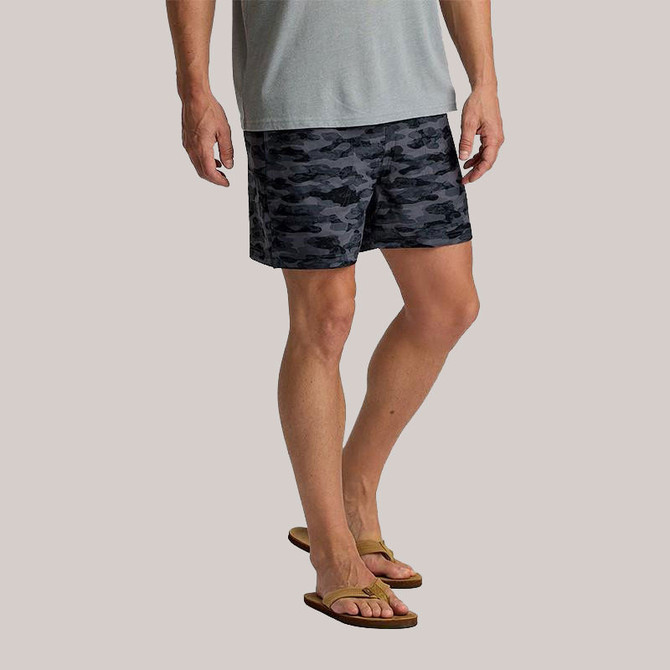 Free Fly Apparel Free Fly Men's Lined Active Breeze Shorts - 5.5-inch Inseam, front view of a man wearing gray and black camo pattern shorts with tan flip-flops, casual summer apparel.