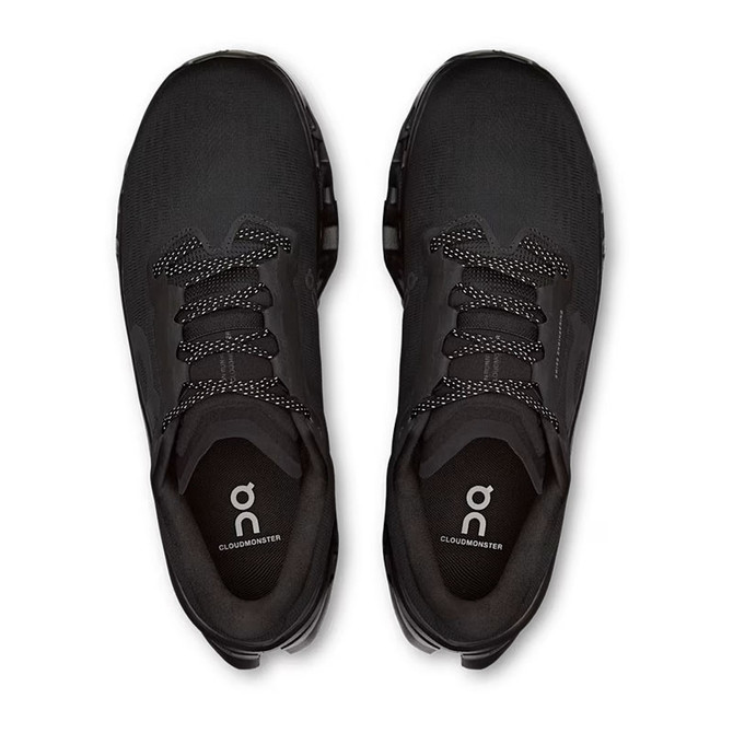 On Running Men's Cloudmonster 3, top view of black athletic running shoes with laces and cushioned sole.