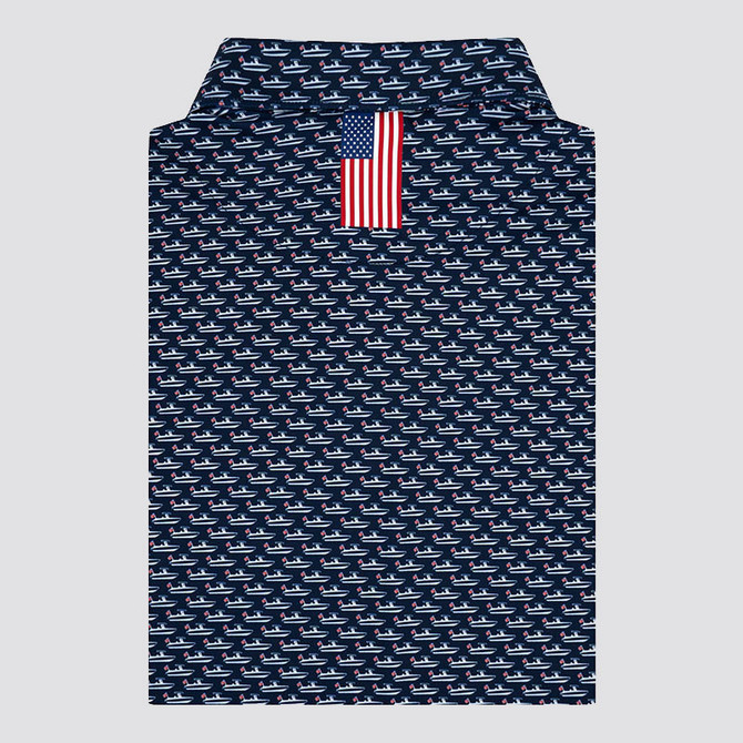 Rhoback Men's The Skipper Performance Polo, navy polo shirt with a pattern of small white and red sailboats and an American flag detail at the collar.