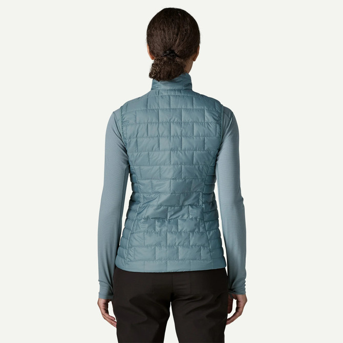 Patagonia Women's Nano Puff Vest, a blue quilted outdoor vest worn by a woman viewed from the back.